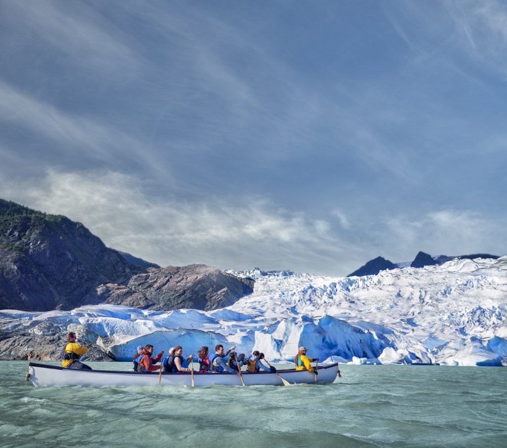 Visitors rowing a canoe to visit Mendenhall Glacier on a Norwegian Cruise