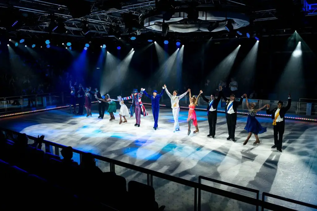 Cast of ice skating show doing a bow