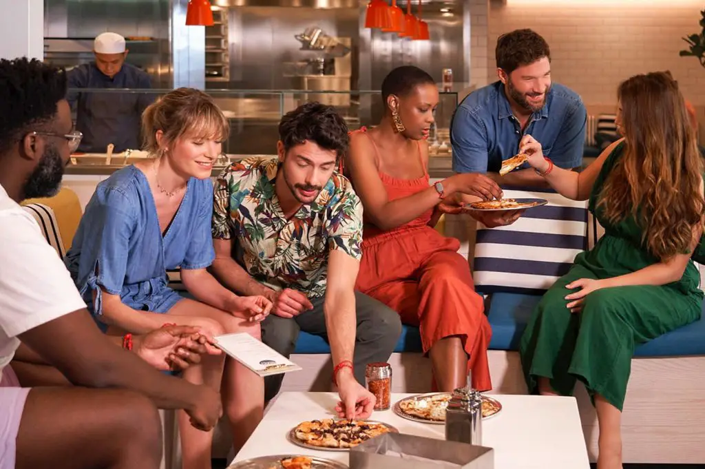 guests eating at the pizza place on virgin voyages scarlet lady