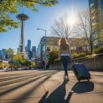 woman with suitcase walking towards space needle