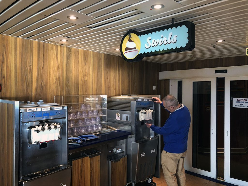 man using swirls ice cream machine on carnival ship