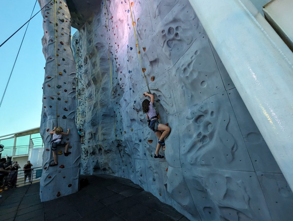 girl climbing rock wall on a cruise ship