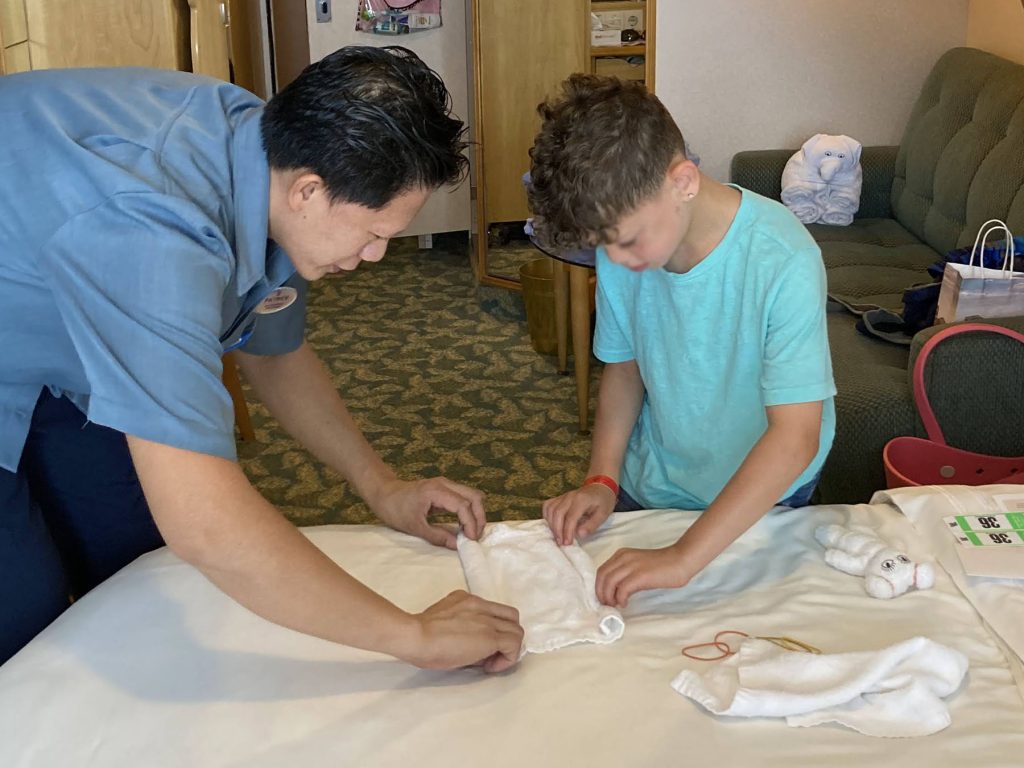 room steward and boy making towel animals