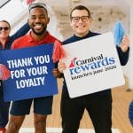 people holding sign about carnival rewards program