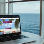 celebrity cruise planner on a laptop by the ocean